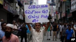 A Sri Lankan Muslim trader holds a placard demanding president Gotabaya Rajapaksa resign during a country wide strike in Colombo, Sri Lanka, Thursday, April 28, 2022. 