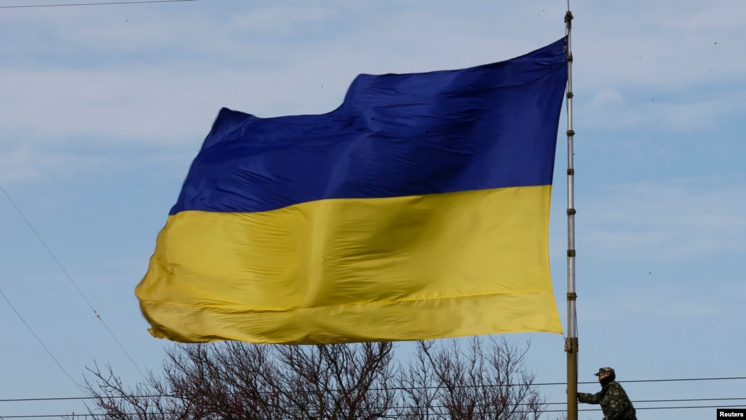 Seorang tentara Ukraina memanjat tiang bendera di pangkalan A2904 sesaat sebelum komando Ukraina kehilangan kendali atas tiang itu oleh orang-orang bersenjata di kota Bakhchisaray, Krimea, 10 Maret 2014. (Foto: Reuters)