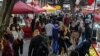 FILE - People walk through a street market in the city center in Sydney, Australia, Nov. 19, 2021. 