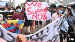 FILE - Protesters hold a banner in support of the National Unity Government (NUG) as they take part in a demonstration against the military coup in Yangon, Myanmar, on July 7, 2021. 