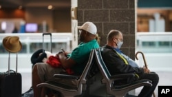 Travelers sit in a waiting area at Rhode Island T.F. Green International Airport in Providence, R.I., April 19, 2022.