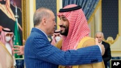 In this photo released by the Saudi Royal Palace, Turkish President Recep Tayyip Erdogan, left, hugs Saudi Arabia's Crown Prince Mohammed bin Salman before a meeting in Jiddah, Saudi Arabia, April 28, 2022. 