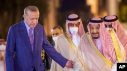 In this photo released by the Saudi Royal Palace, Turkish President Recep Tayyip Erdogan, left, accompanies Saudi Arabia's King Salman before a meeting in Jiddah, Saudi Arabia, April 28, 2022.