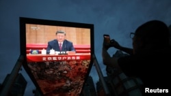 中国北京，一块巨型室外屏幕上播放着中国国家主席习近平在纪念已故领导人江泽民诞辰100周年活动上发表讲话的画面。(2026年8月17日)