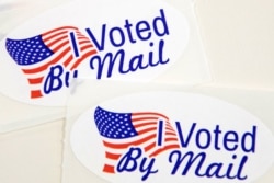 Stickers that read "I Voted By Mail" sit on a table waiting to be stuffed into envelopes by absentee ballot election workers at the Mecklenburg County Board of Elections office in Charlotte, NC on Sept.4, 2020.