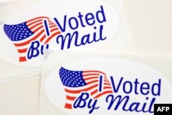 Stickers that read "I Voted By Mail" sit on a table waiting to be stuffed into envelopes by absentee ballot election workers at the Mecklenburg County Board of Elections office in Charlotte, NC on Sept.4, 2020.