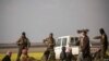 Sujetos sospechosos de ser combatientes del Estado Islámico llegan a un centro de investigación en Baghuz, Siria.
