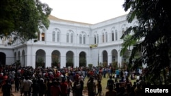 Para demonstran melakukan protes di dalam Istana Presiden dan Sekretariat Presiden di Kolombo Minggu (10/7), setelah Presiden Gotabaya Rajapaksa melarikan diri, di tengah krisis ekonomi negaranya.