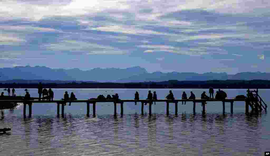 People enjoy the sunny weekend autumn weather at Lake Starnberger See in Seeshaupt near Munich, Germany.