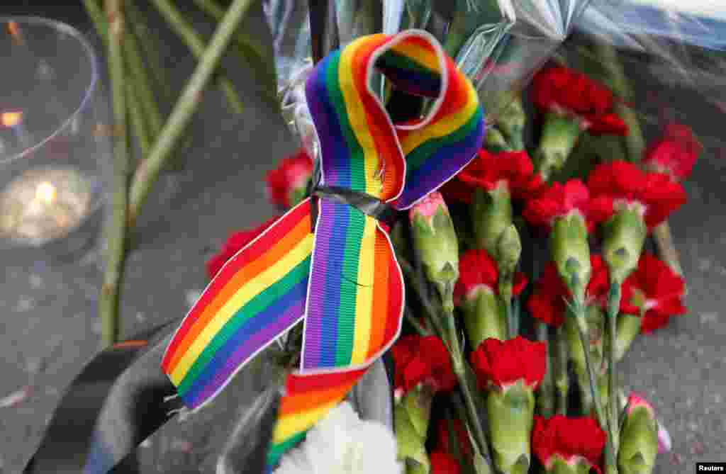 A rainbow ribbon, a candle and flowers for the victims of the shooting at a gay nightclub in Orlando are seen in front of the U.S. Embassy in Moscow, Russia.