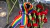 A rainbow ribbon, a candle and flowers for the victims of the shooting at a gay nightclub in Orlando are seen in front of the U.S. Embassy in Moscow, Russia.