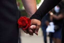 The fiancé of George Floyd, left, holds hands with a supporter at North Central University after a memorial service for Floyd, June 4, 2020, in Minneapolis.
