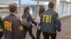这张视频截图来自2026年10月4日美国检察官比尔·埃萨利通过X社交媒体账户发布的画面，显示联邦调查局特工在洛杉矶国际机场逮捕张婉莹(右二)。