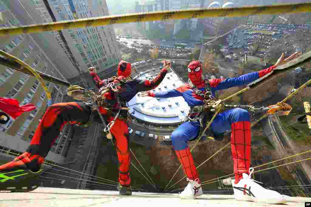 Para pemain akrobat yang berpakaian kostum super hero memberikan &quot;kejutan&quot; di jendela kamar pasien anak-anak yang dirawat di sebuah rumah sakit anak &quot;San Paolo&quot; di Milan, Italia. (Foto: AP)