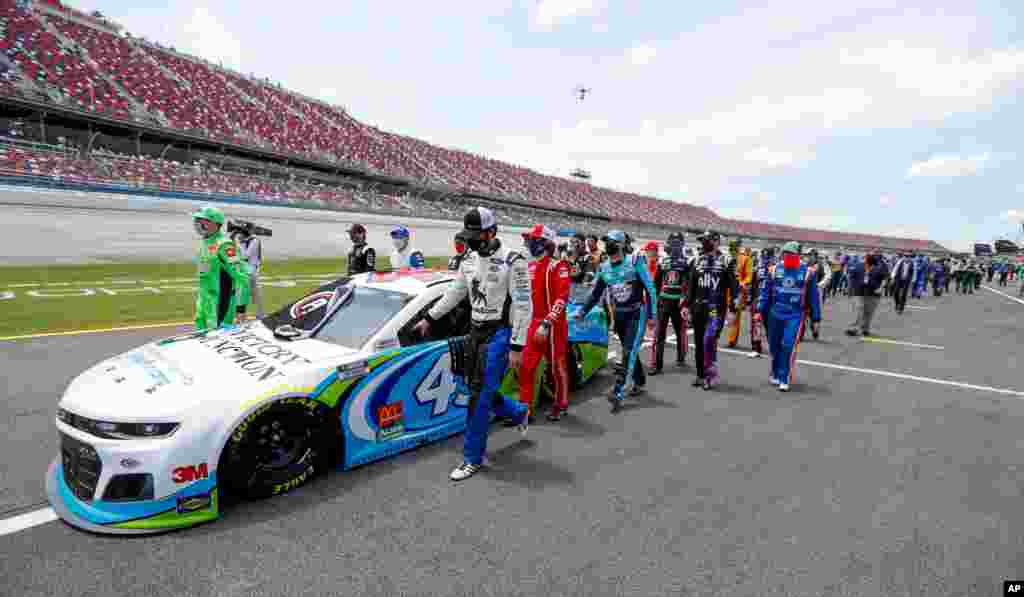 NASCAR drivers and crews push the car of Bubba Wallace to the front of the field prior to the start of the NASCAR Cup Series auto race at the Talladega Superspeedway in Talladega, Alabama, June 22, 2020.