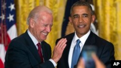 Wapres AS Joe Biden, kiri, dan Presiden Barack Obama bereaksi setelah memerintahkan seorang aktivis berulangkali mengganggu pidatonya keluar dari Ruangan Timur Gedung Putih pada sebuah resepsi merayakan Bulan LGBT di Washington, Rabu (24/6).