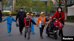 Sejumlah orang tua menjemput anak-anak dari sebuah sekolah di Beijing, China, 6 April 2021. (Foto: REUTERS/Thomas Peter)