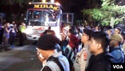 Polisi menyiapkan armada bus untuk memulangkan mahasiswa Papua domisili luar Surabaya ke Malang dan Yogyakarta (foto: Petrus Riski/VOA).