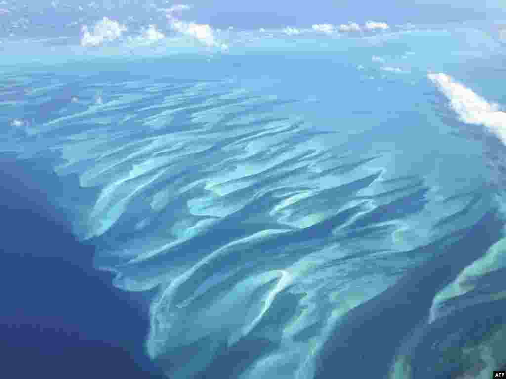 Shades of turquoise waters surround sandbanks off Eleuthera in the Bahamas, as viewed from a plane.