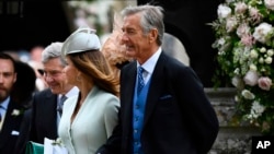 FILE - David Matthews and his wife, Jane, parents of James Matthews, are pictured at their son's wedding to Pippa Middleton, the sister of Kate, Duchess of Cambridge, at St Mark's Church in Englefield, England, May 20, 2017. A source has told Reuters that David Matthews was arrested March 27, 2018, and formally put under investigation for suspected rape of a minor under his authority about two decades ago.