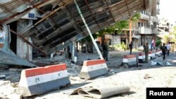 Syrian army soldiers stand at a site of an explosion in Bab Tadmor in Homs, Syria in this handout picture provided by SANA, September 5, 2016.