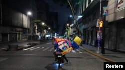 Simpatizantes portan una bandera y un cartel alegórico al presidente venezolano Nicolás Maduro celebran después de que la autoridad electoral en Venezuela anunciara que Maduro ganó un tercer mandato, en las elecciones presidenciales, en Caracas, el 29 de julio de 2024