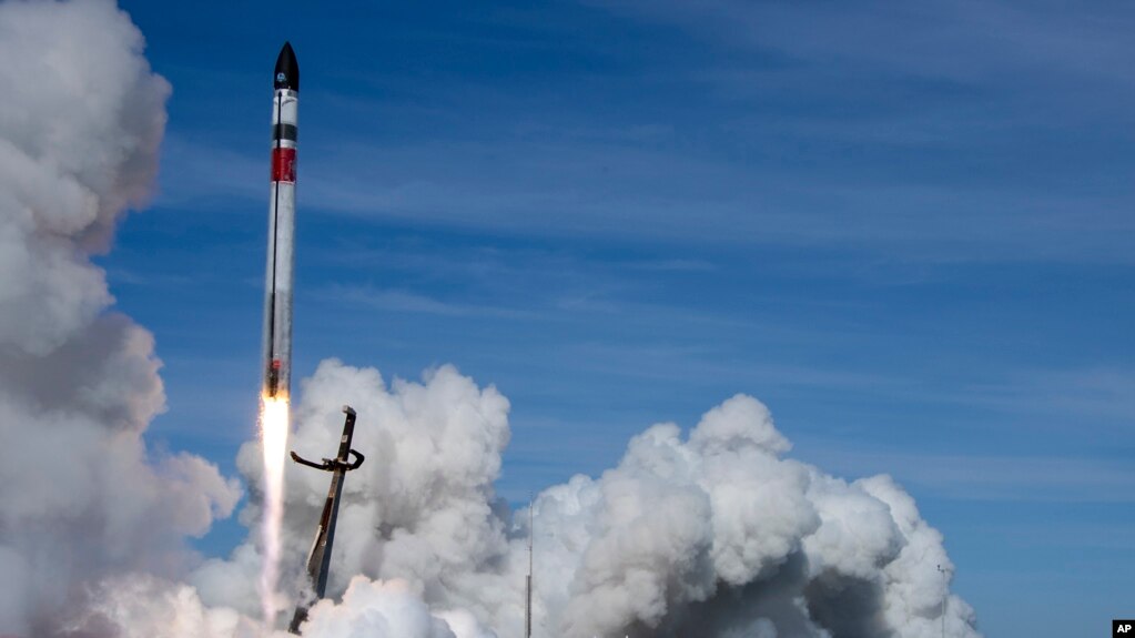 In this image made from video supplied by Rocket Lab, a helicopter hovers above as it attempts to capture Electron's first stage in mid-air by helicopter above New Zealand, Tuesday, May 3, 2022. (Rocket Lab via AP)