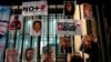 FILE - A woman posts photos of murdered journalists during a protest against the murder of journalists Lourdes Maldonado and Margarito Martínez in Mexico City, Jan. 25, 2022. Mexico ranks as one of the most dangerous places in the world to practice journalism outside a war zone.