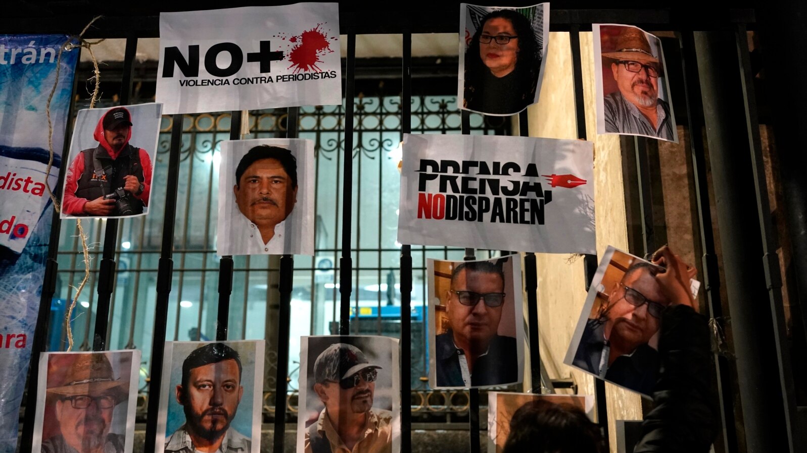 FILE - A woman posts photos of murdered journalists during a protest against the murder of journalists Lourdes Maldonado and Margarito Martínez in Mexico City, Jan. 25, 2022. Mexico ranks as one of the most dangerous places in the world to practice journalism outside a war zone.