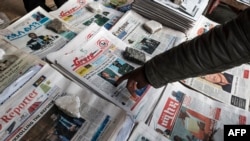 FILE - A man points to a newspaper among the stacks of offerings, in Addis Ababa, Ethiopia, June 24, 2019. 