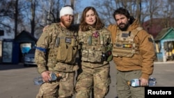 FILE - Members of a group of U.S. volunteer fighters who have taken up arms alongside Ukrainian soldiers, stand in front of a hospital in the town of Brovary, near Kyiv, amid Russia's invasion of Ukraine, March 20, 2022.
