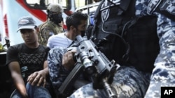 FILE - Men are detained by police, suspected of a homicide near a market in San Salvador, El Salvador, on Sunday, March 27, 2022. Five organizations have documented more than 300 complaints of human rights violations since the president of El Salvador, Na