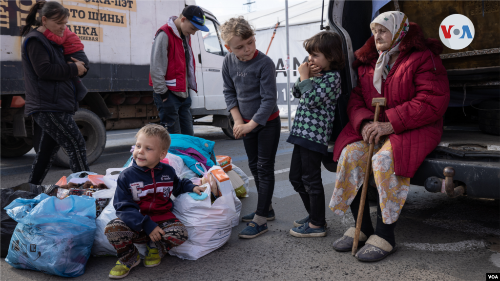 Familia de refugiados espera la evacuación en el centro logístico de refugiados en Zaporiyia.