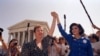 FILE - Norma McCorvey, Jane Roe in the 1973 court case, left, and her attorney Gloria Allred hold hands as they leave the Supreme Court building in Washington, DC., April 26, 1989 after sitting in while the court listened to arguments in a Missouri abort