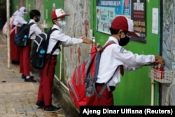 Siswa SD yang memakai masker sedang mencuci tangan usai sekolah, di Jakarta, 30 Agustus 2021. (Foto: REUTERS/Ajeng Dinar Ulfiana)
