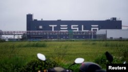 FILE - Tesla signage is seen at its factory in Shanghai, China, May 13, 2021.