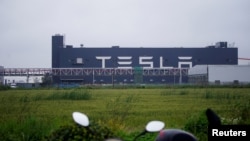 FILE - Tesla signage is seen at its factory in Shanghai, China, May 13, 2021.