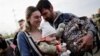 A family of Ukrainian evacuees from Mariupol embraces after arriving at a registration center for internally displaced people in Zaporizhzhia, Ukraine, May 3, 2022.
