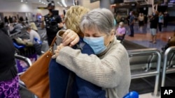 Family members embrace after a flight from Los Angeles arrived at Auckland International Airport as New Zealand's border opened for visa-waiver countries on May 2, 2022.