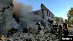 Firefighters spray water onto fire in a destroyed building after a missile strike, in Odesa, Ukraine, as seen in this still image taken from a handout video released May 2, 2022. 