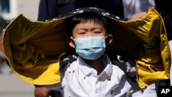 Un niño con una máscara hace fila para hacerse una prueba de COVID-19 el 1 de mayo de 2022 en Beijing, China.