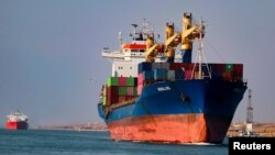 Shipping containers pass through the Suez Canal in Suez, Egypt, Feb. 15, 2022.