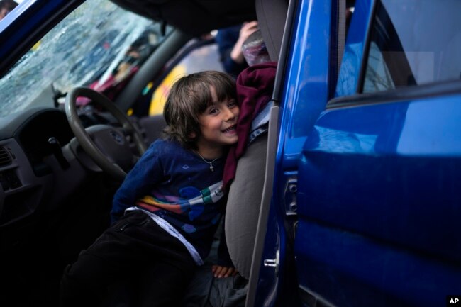 A child sits in a car as his family waits to be processed upon their arrival from Mariupol at a reception center for displaced people in Zaporizhzhia, Ukraine, Monday, May 2, 2022. (AP Photo/Francisco Seco)