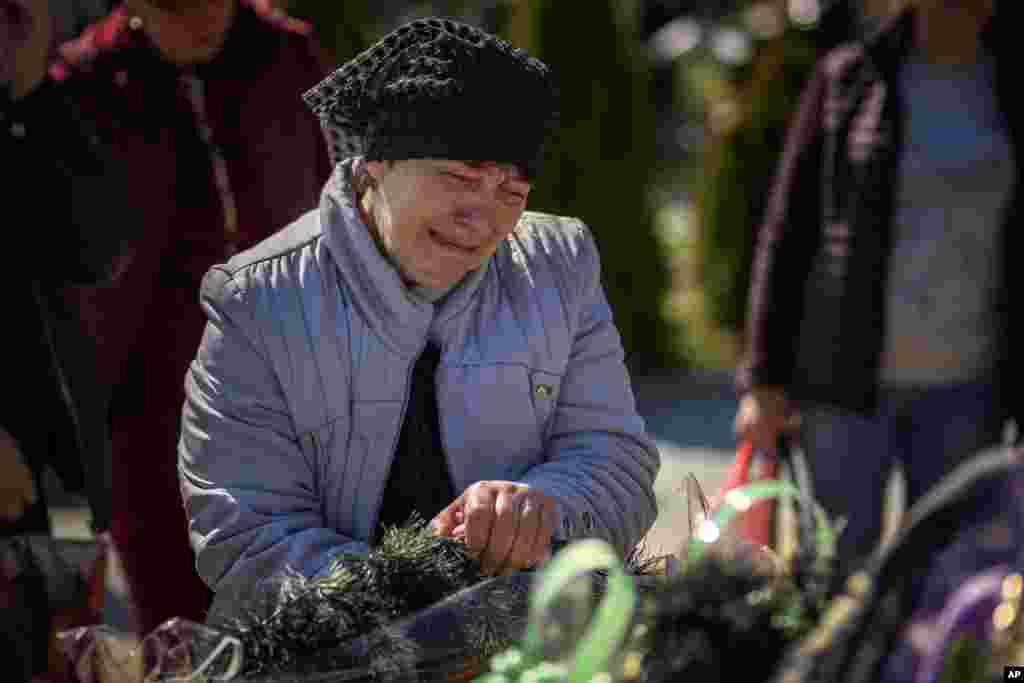 The mother of Oleksandr Mozheiko, 31, an Irpin Territorial Defense soldier killed by Russian army, cries at his grave at the cemetery of Irpin, on the outskirts of Kyiv, Ukraine.