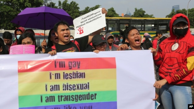 Sejumlah aktivis LGBT meneriakan berbagai macam slogan dalam aksi protes terhadap revisi KUHP yang akan melarang hubungan sesama jenis di depan Gedung DPR di Jakarta, pada 12 Februari 2018. (Foto: AP/Tatan Syuflana)