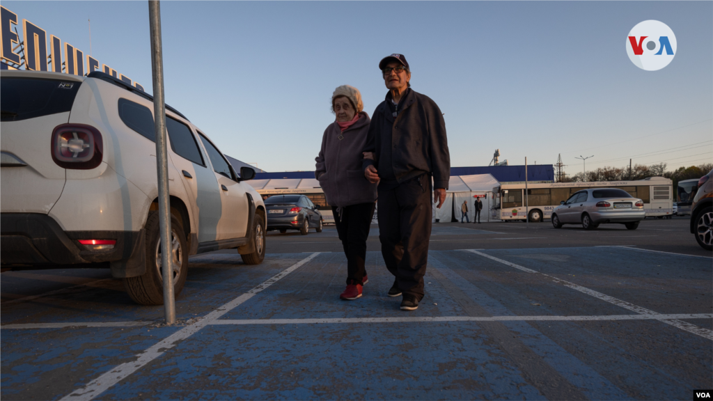 Una pareja de jubilados camina en el centro de refugiados de Zaporiyia.