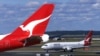 FILE - Two Qantas passenger jetsat Sydney International Airport, in Sydney, Australia, July 27, 2000. Researchers say in 2023 Australia's greenhouse gas emissions increased for the first time in five years, mostly because of an increase in post-COVID domestic air travel.