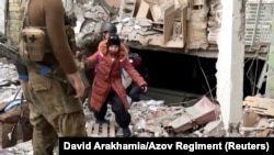 A child emerges from the Azovstal steel plant during UN-led evacuations after nearly two months of siege warfare on Mariupol, Ukraine, by Russia, in this still image from a video released May 1, 2022. Credit: David Arakhamia/Azov Regiment/Handout via REUTERS