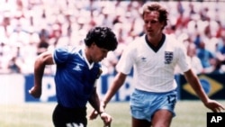 ARCHIVO - Diego Maradona (izquierda) esquiva al inglés Trevor Steven durante el partido de la Copa Mundial en el Estadio Azteca, el 22 de junio de 1986. La camiseta que usó el astro argentino en ese partido, en el que el controvertido gol de la “mano de Dios” y luego el mejor gol de la historia de los mundiales está en venta, y la subastadora Sotheby’s estima que recaudará más de 4 millones de libras (5,2 millones de dólares) en una subasta online que comienza el 20 de abril. (AP Foto)