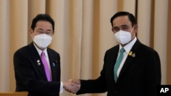 Japanese Prime Minister Fumio Kishida, left, shakes hands with Thailand's Prime Minister Prayuth Chan-ocha after a joint press conference at the government house in Bangkok, Thailand, Monday, May 2, 2022. (AP Photo/Sakchai Lalit)